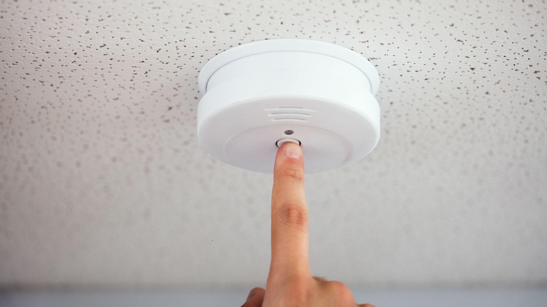 person turning on smoke alarm
